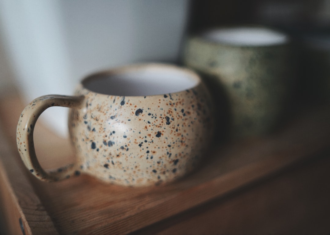 Handmade ceramic mug with visible throwing rings and organic glaze texture